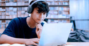 A high school male student studying on his laptop.