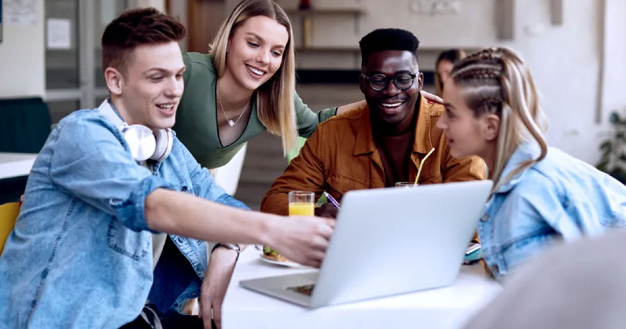 A group of students discussing around a laptop 
