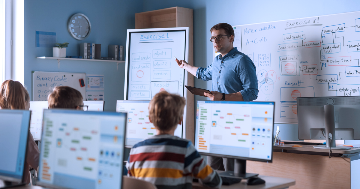Image of a teacher using interactive digital tools to explain lessons in a classroom.
