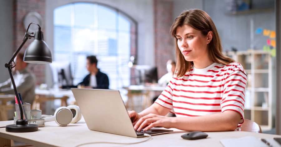 A product lead with a laptop in an office setting, depicting thoughtful edtech UX decisions in a collaborative digital learning environment.