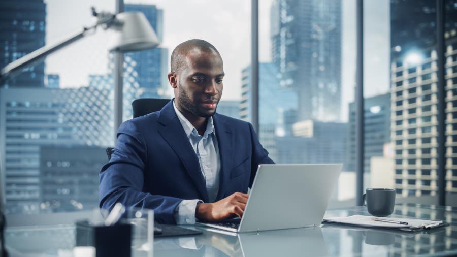 A working professional working on a laptop in a modern office setting, while conducting EdTech usage telemetry validation to analyze platform engagement data.