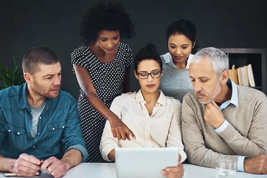 A diverse group of professionals reviewing content together on a tablet, focused on digital accessibility in education and inclusive learning experiences.