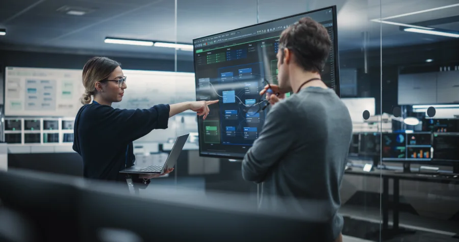 A software development team reviewing system architecture and workflow specifications on a large digital screen, showcasing spec-driven AI development workflow in an enterprise engineering environment.